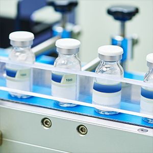 Se colocan 4 botellas de reactivo en la línea de producción farmacéutica.